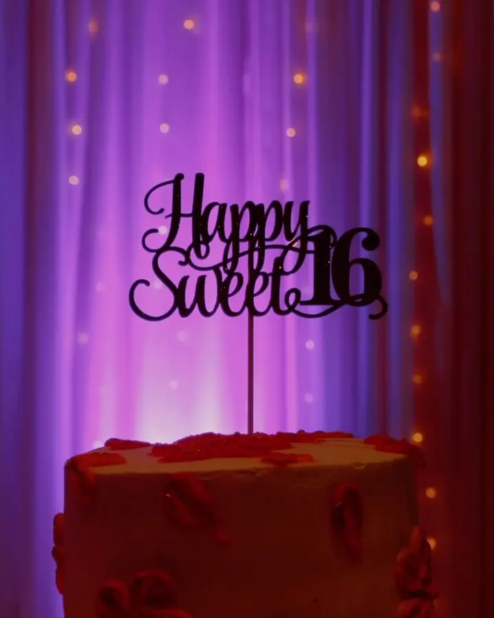Happy Sweet 16 cake topper under purple lights