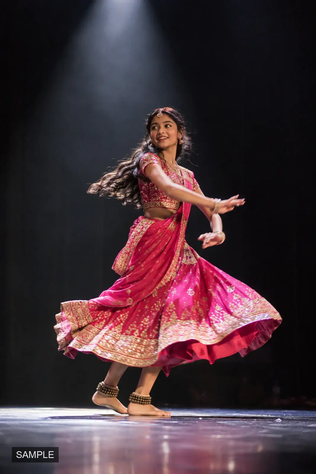 Dancer mid-turn in a bright costume under a single spotlight