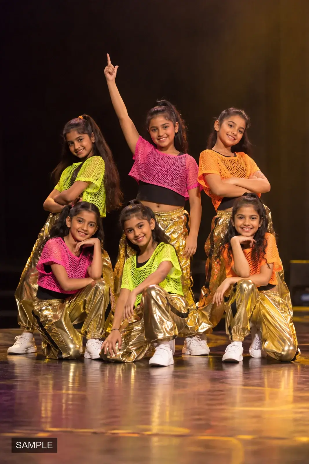 Young dancers in sequined costumes holding a pose together